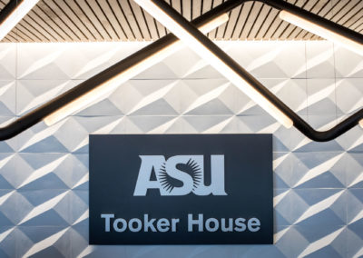 Close-up of the ASU Tooker House signage with specialized tube lighting above it.