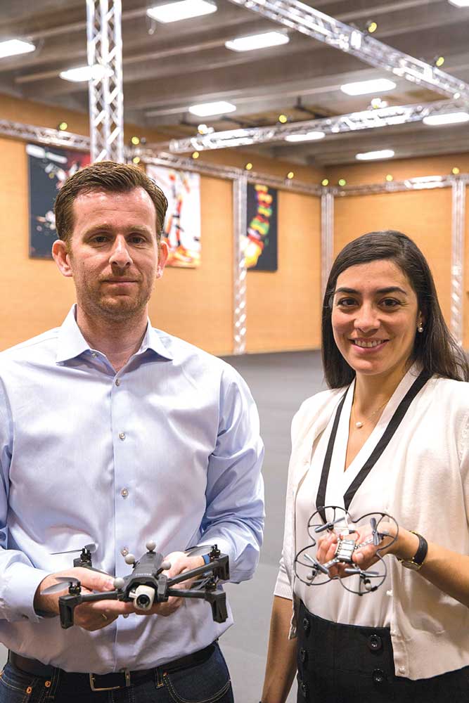 Panos Artemiadis and Stephanie Gil stand together for a photo in the ASU Drone Studio, holding devices they test in the facility