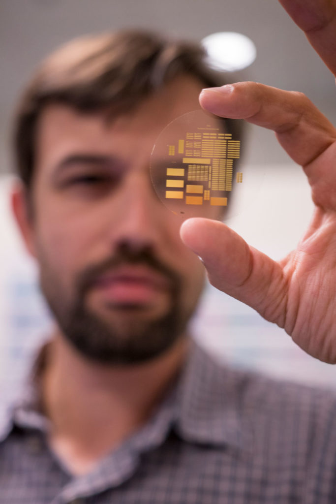 George Trichopoulos holds a small array of antennas in a wafer.