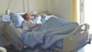 A woman rests in a hospital bed with no visitors