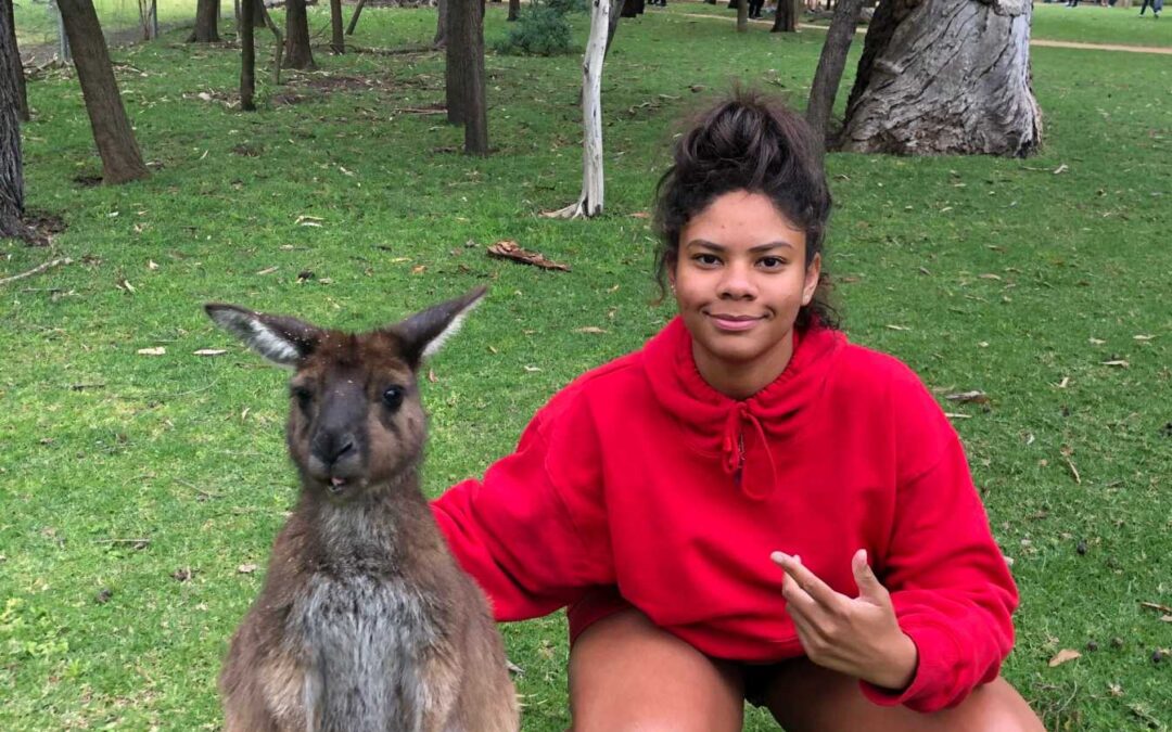 Olivia Sparks sits next to a wallaby