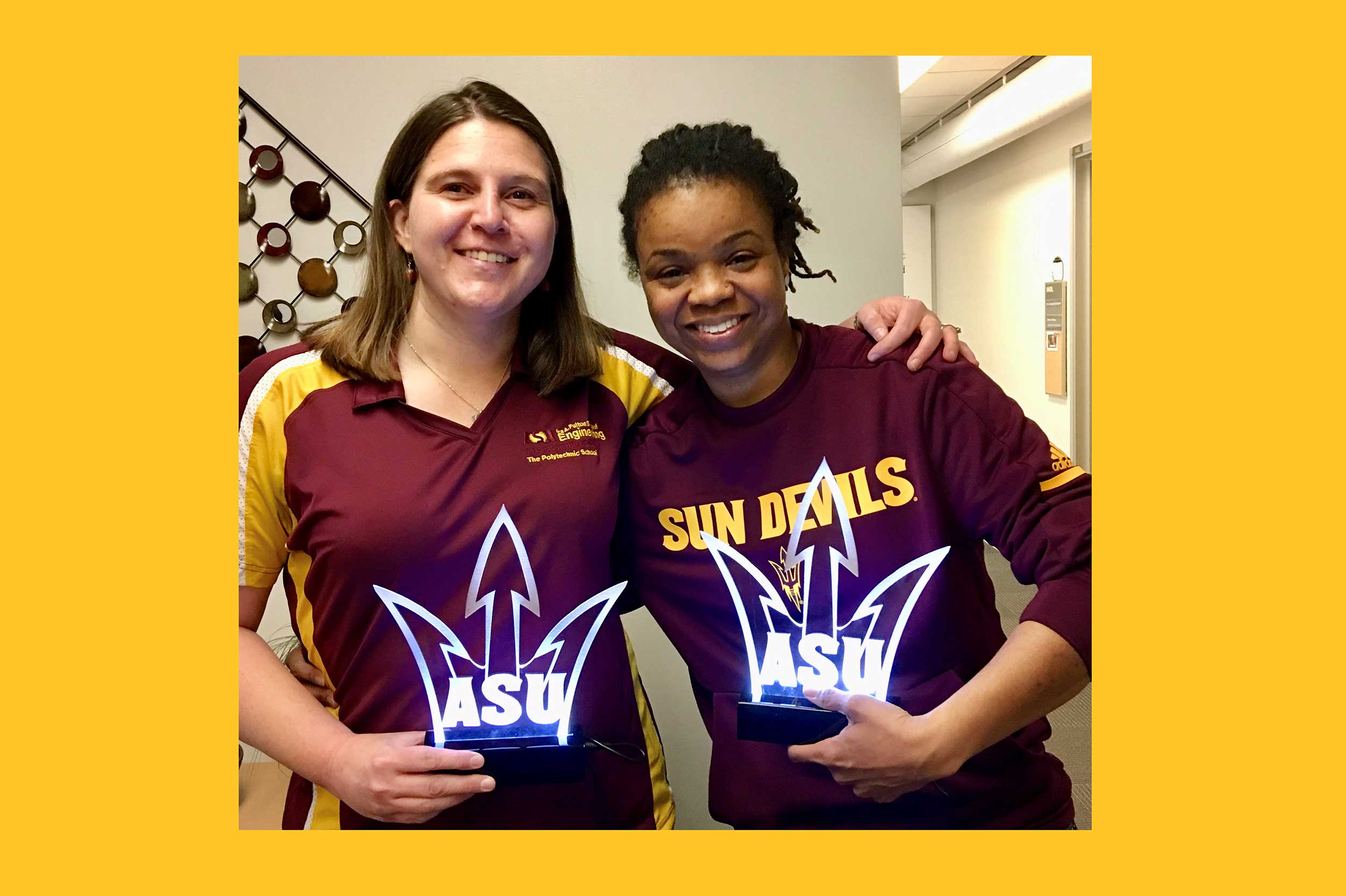Jennifer Bekki and Brooke Coley stand together, arms around each other, holding their awards from ASU