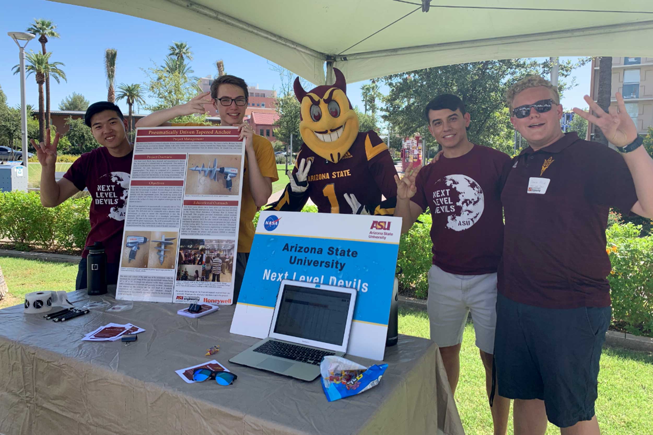 Four Next Level Devils members pose with ASU's mascot Sparky at a 2019 event