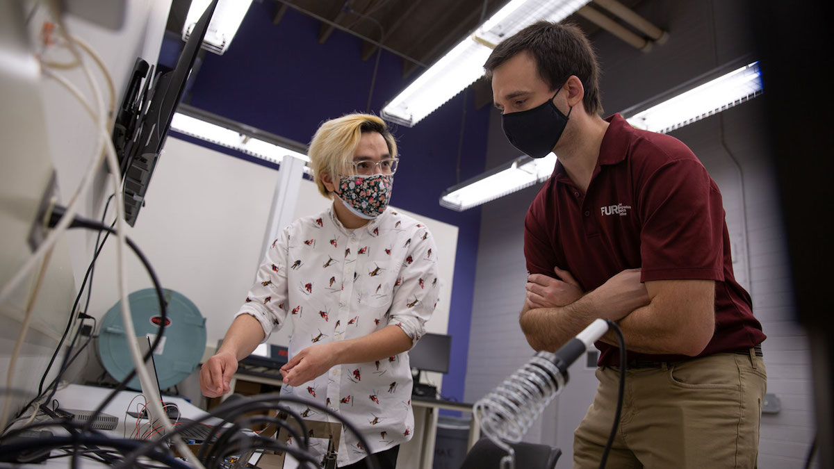 Jesus Pena works with his mentor Associate Professor Jay Oswald in Oswald's lab