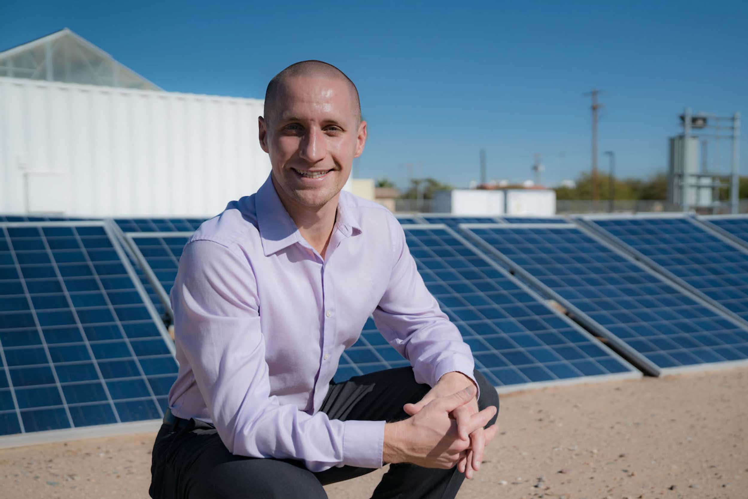 Portrait of Dr. Nathan Johnson outdoors near an array of solar panels