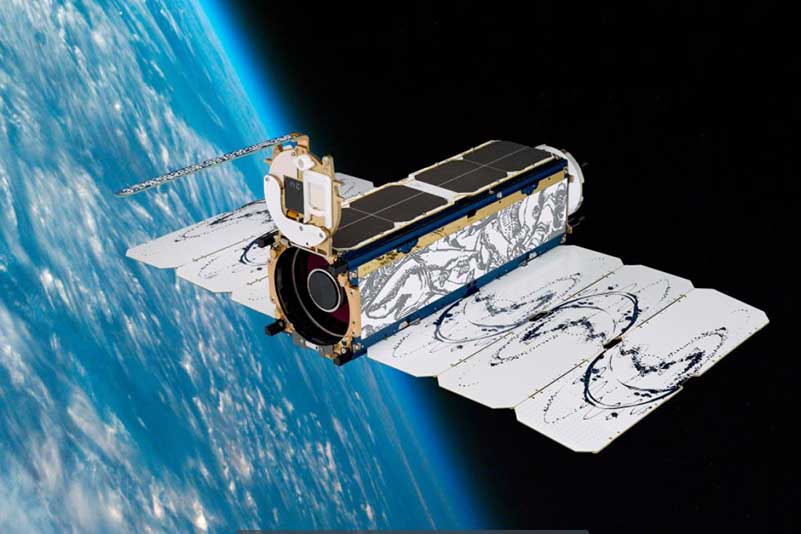 Graphic representation of a "Dove" model satellite from aerospace company Planet orbiting Earth.