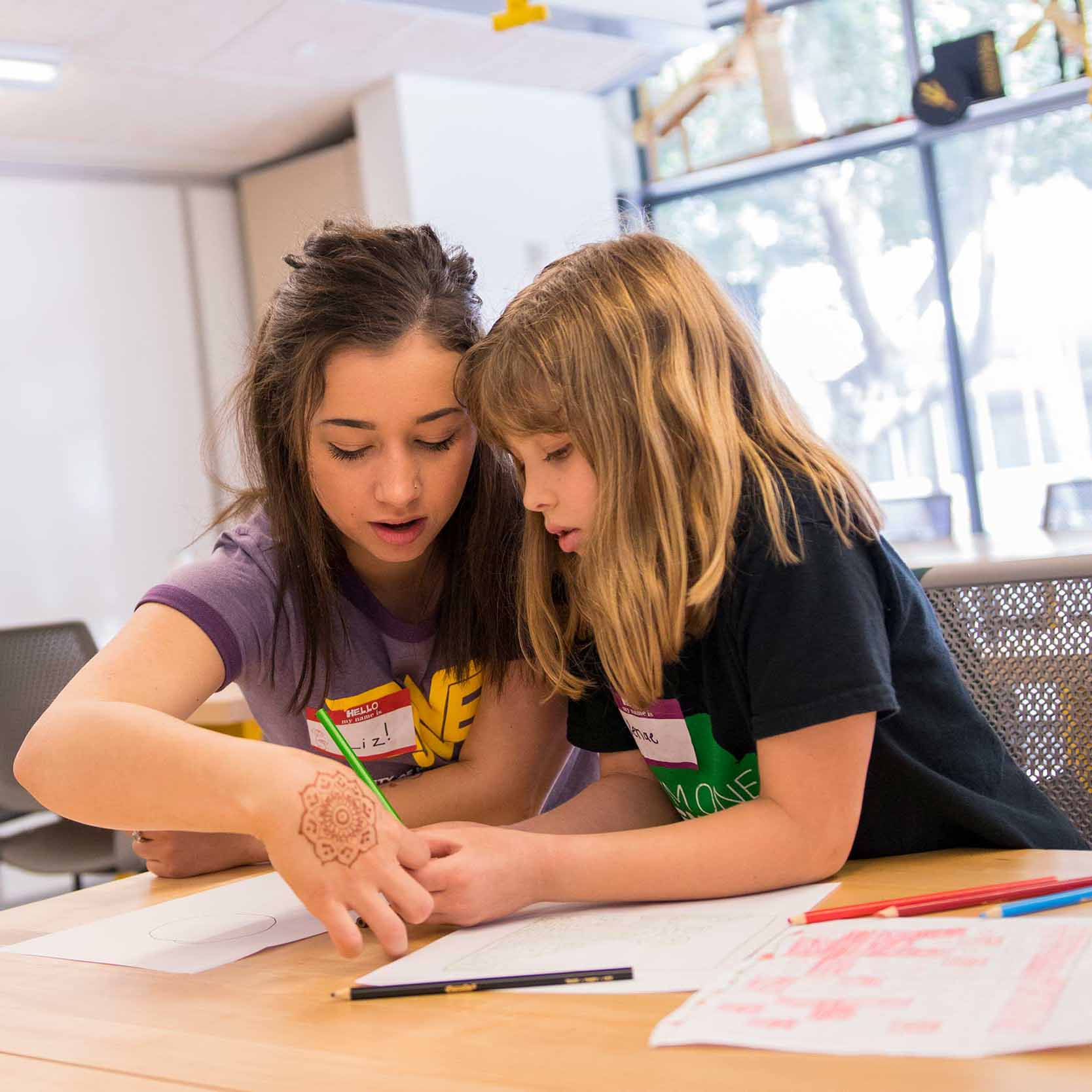 Elizabeth Jones helps an elementary-aged girl with an engineering project