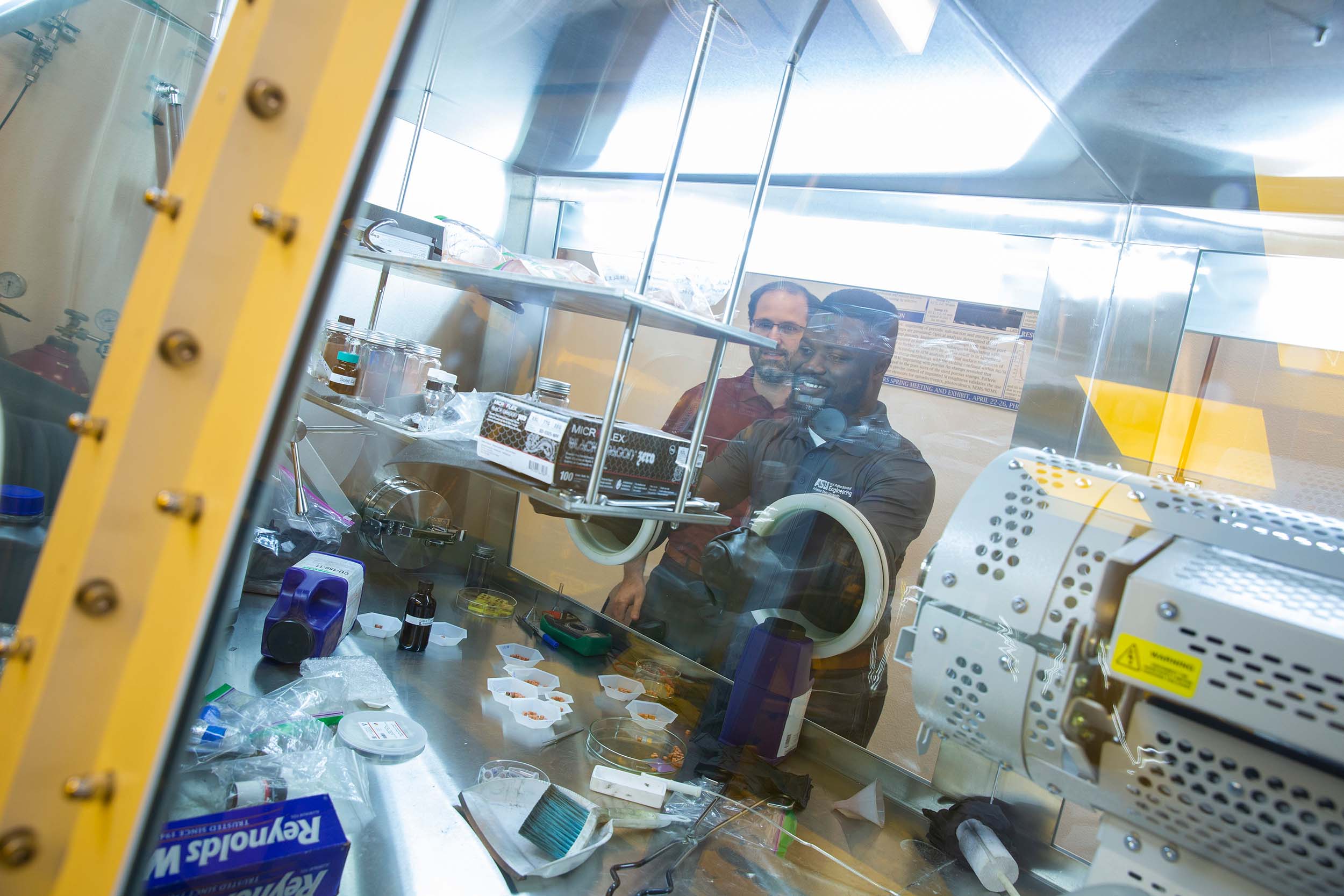 ASU professor Bruno Azeredo works in a lab with graduate student Emmanuel Dasinor.