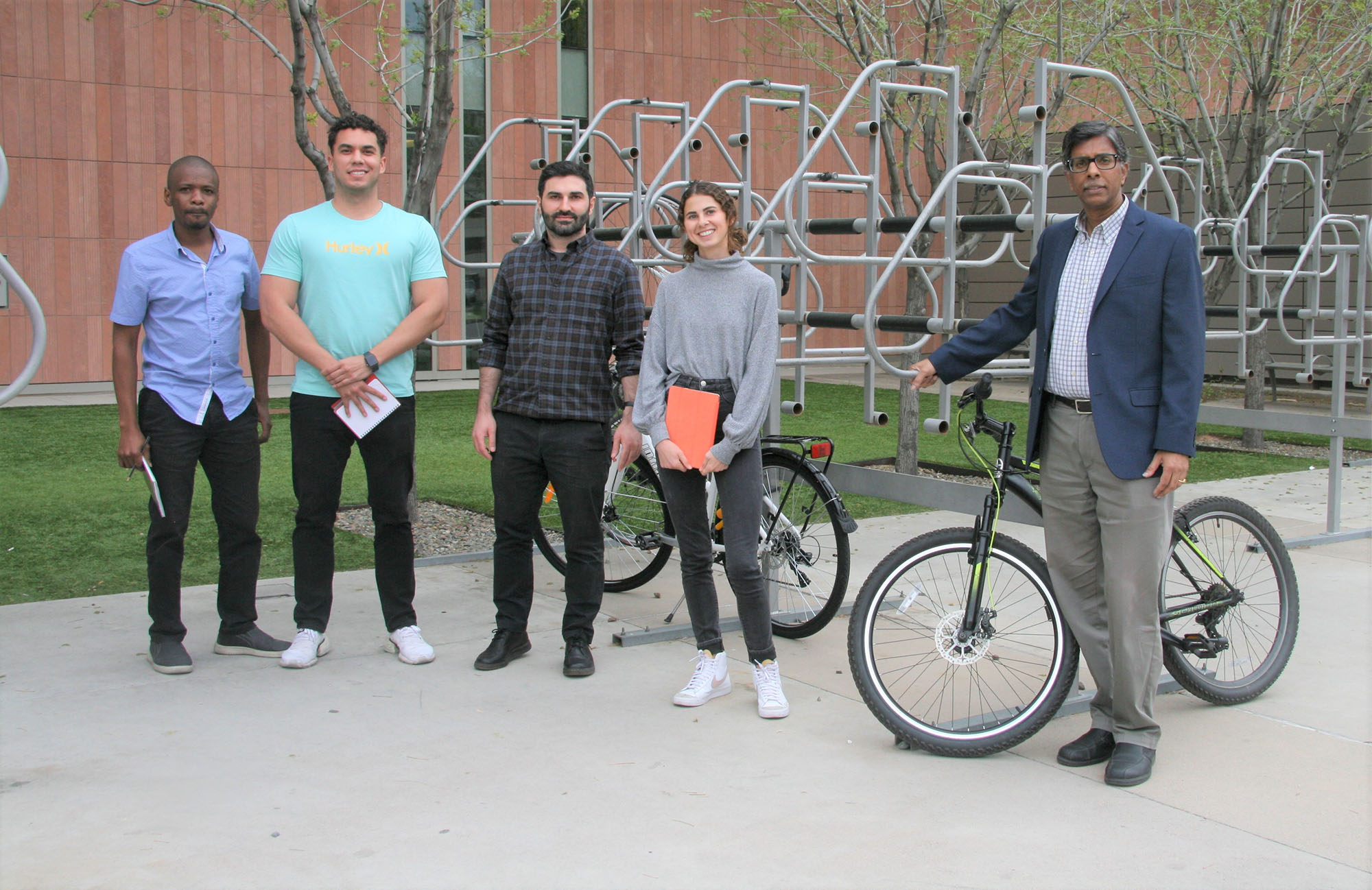 Four researchers stand in a group near an ASU bike rack next to Ram Pendyala.