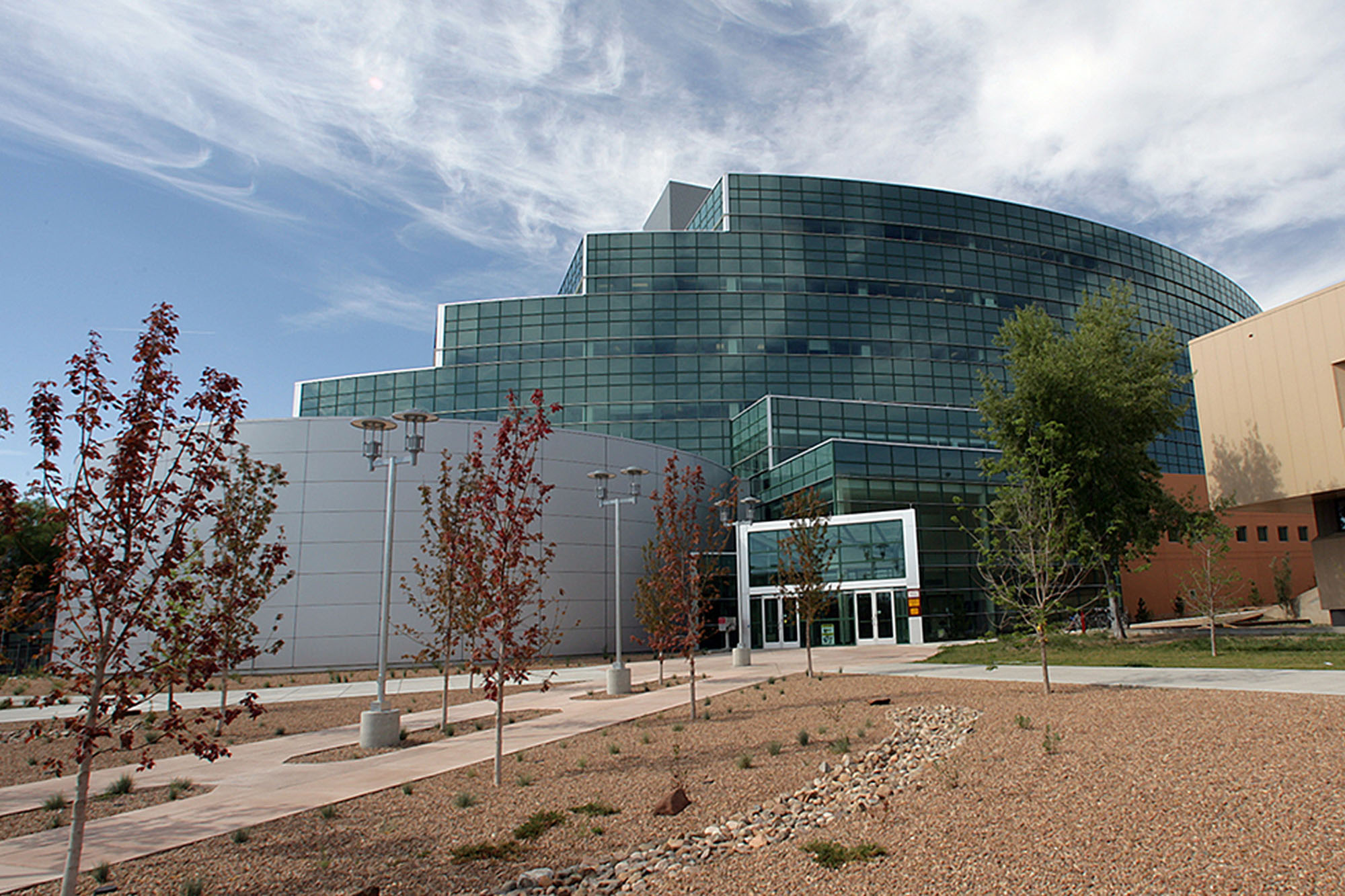 The National Nuclear Security Building at the Los Alamos National Laboratory in Los Alamos, New Mexico. It is mostly glass and has a curved, stepped shape, about 5 floors high.