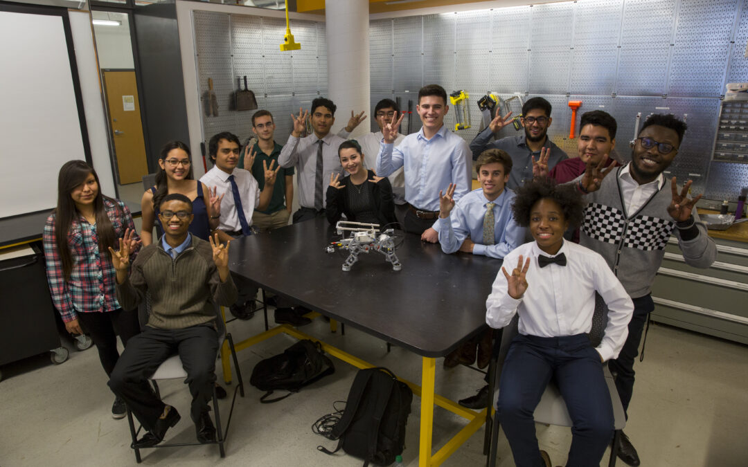 Students pose around a robot.