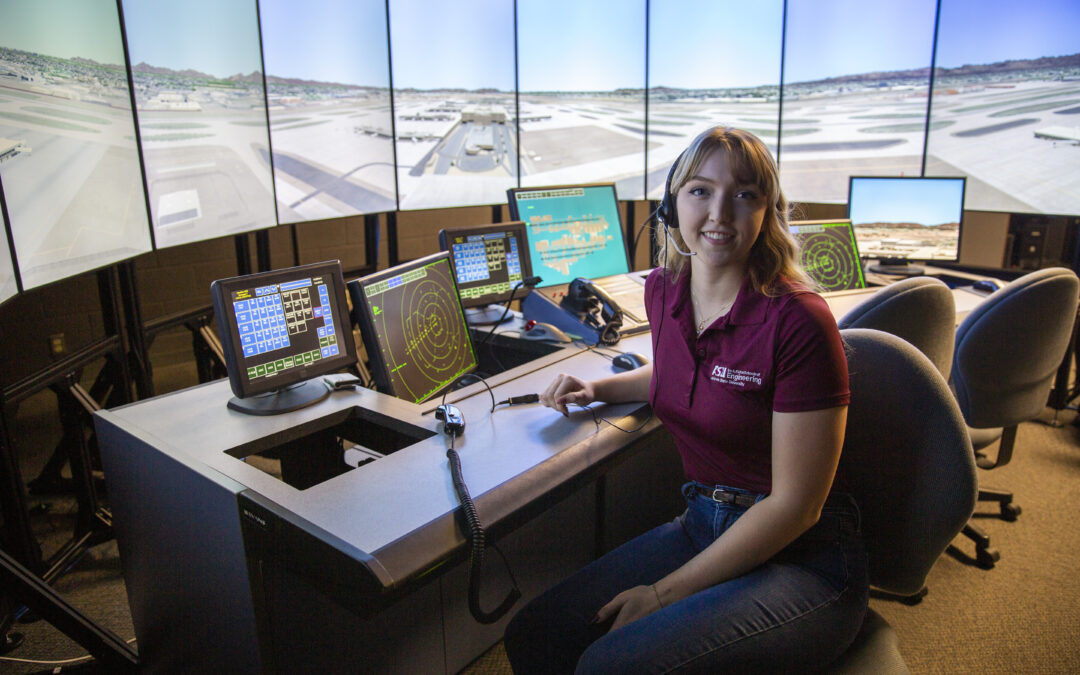 A student sits in front of a flight simulator.