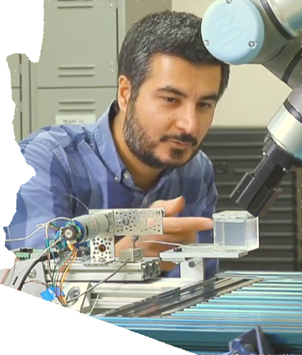 An ASU researcher looks on as a robot arm performs activities interacting with a clear cube. The image is in the shape of the state of Arizona.